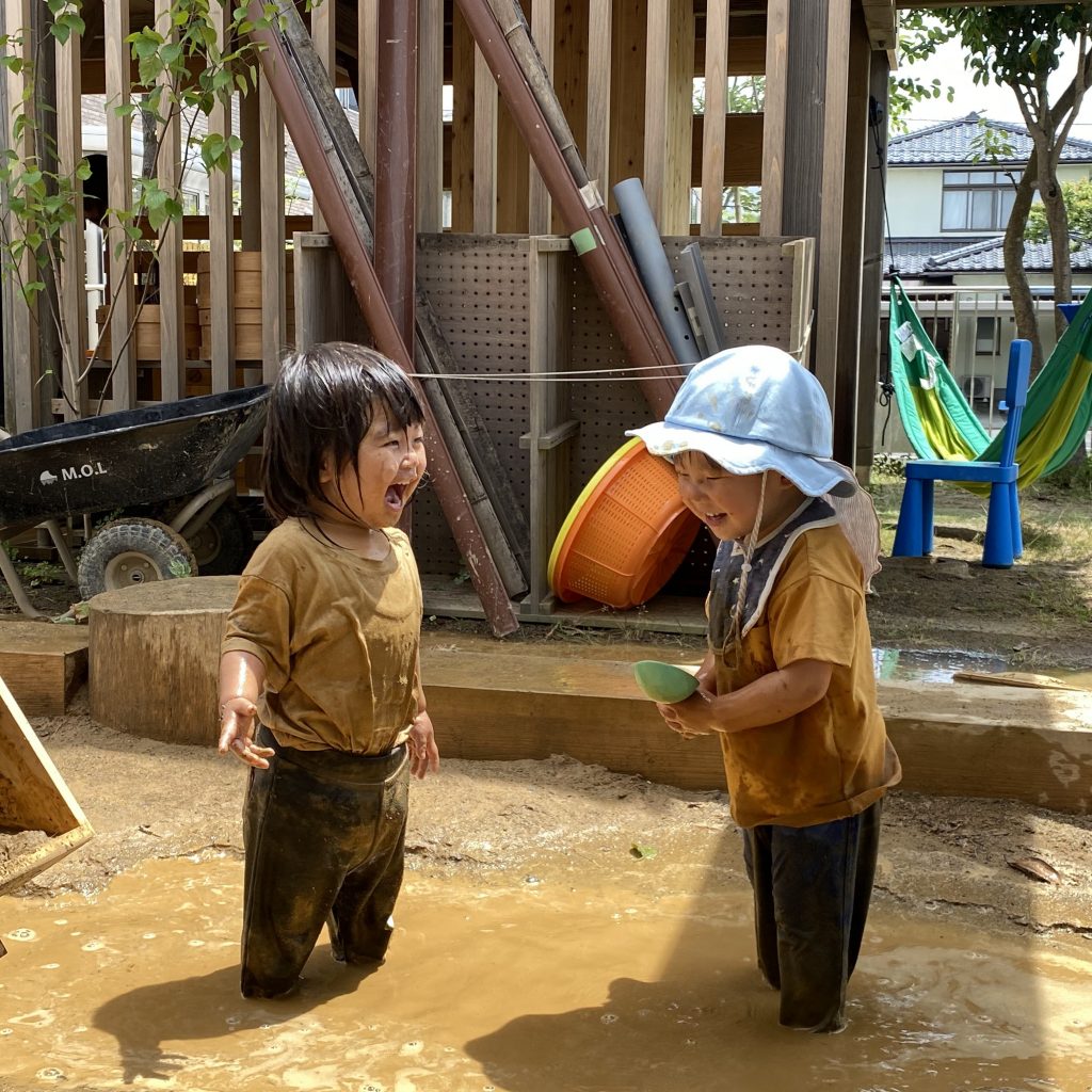 園庭で水遊びをするこどもたち