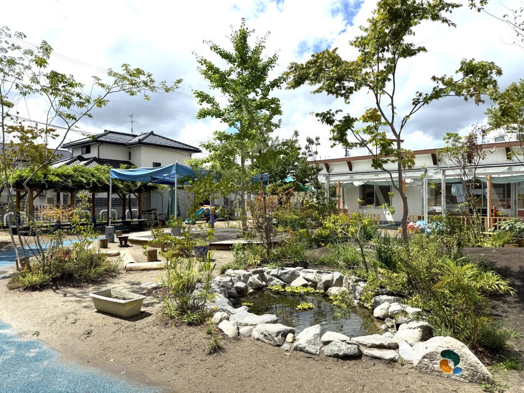 宮城県バンビの森こども園の自然豊かな園庭。ビオトープがランドスケープに貢献している。